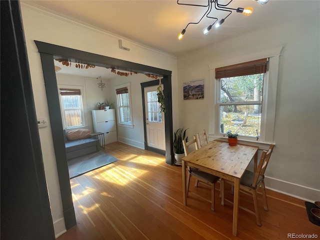 dining space featuring hardwood / wood-style floors, a chandelier, plenty of natural light, and ornamental molding