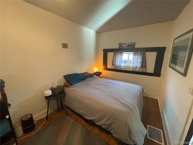 bedroom with hardwood / wood-style floors and vaulted ceiling