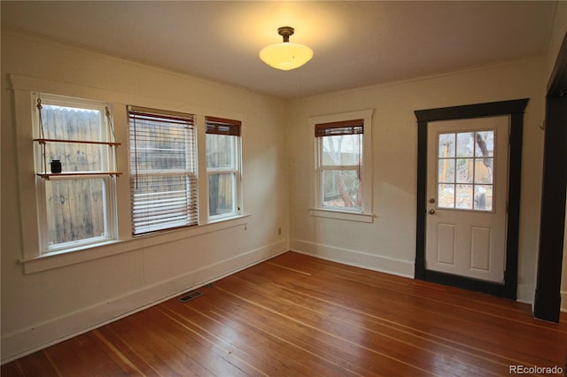 foyer entrance with hardwood / wood-style flooring and crown molding