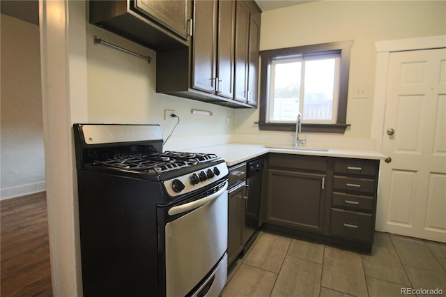 kitchen featuring dishwasher, sink, dark brown cabinetry, and stainless steel gas range