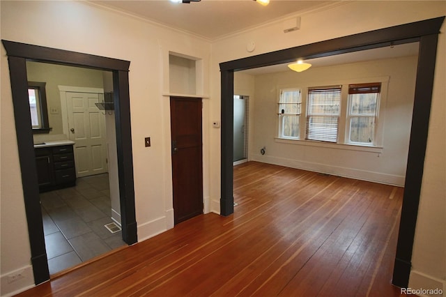 empty room with dark hardwood / wood-style floors and ornamental molding