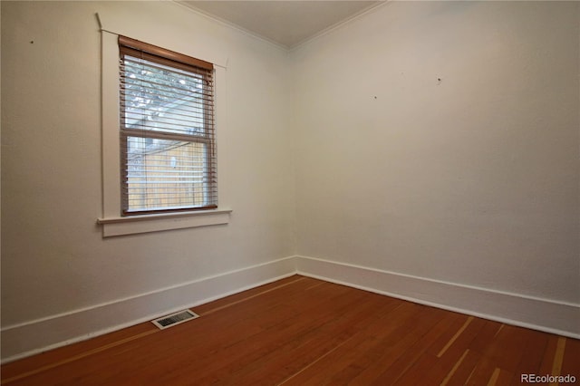 unfurnished room featuring hardwood / wood-style floors and ornamental molding