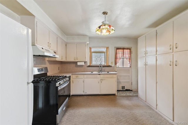 305 W Brookside St, Colorado Springs, CO 80905 - kitchen with stainless steel gas stove, under cabinet range hood, freestanding refrigerator, light countertops, and backsplash