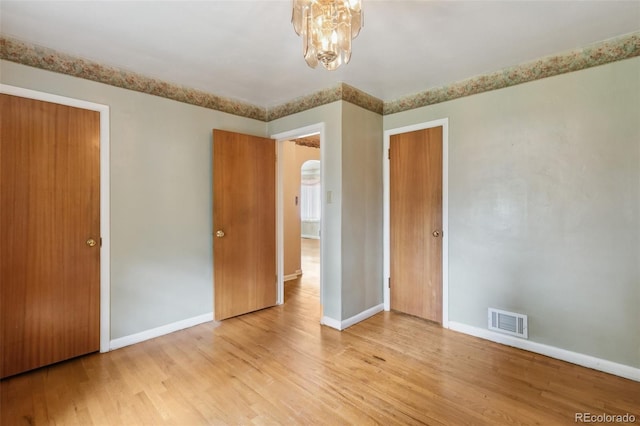 305 W Brookside St, Colorado Springs, CO 80905 - unfurnished bedroom featuring wood finished floors and a chandelier