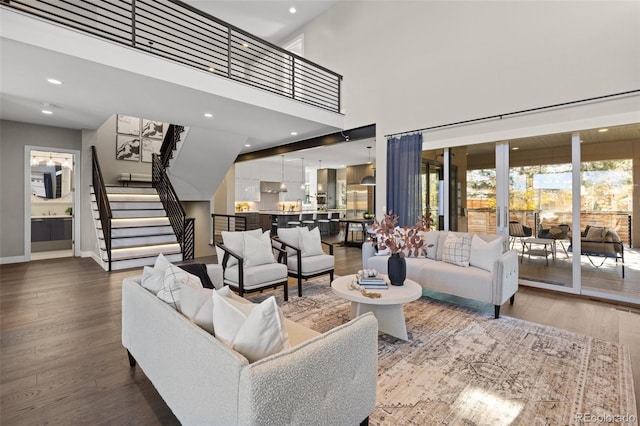 living room featuring a towering ceiling and wood-type flooring