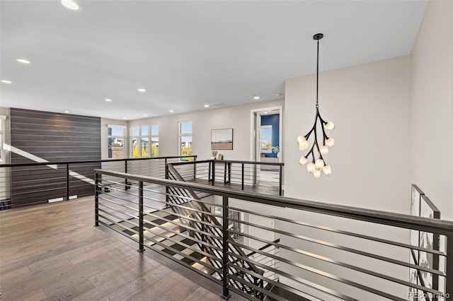 hall featuring an inviting chandelier and hardwood / wood-style flooring