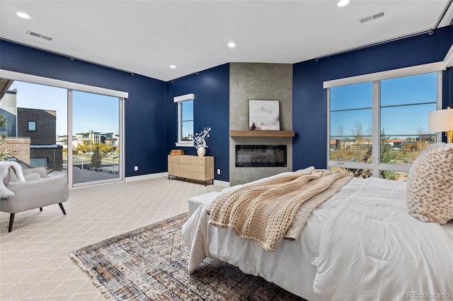 bedroom featuring a large fireplace and carpet flooring