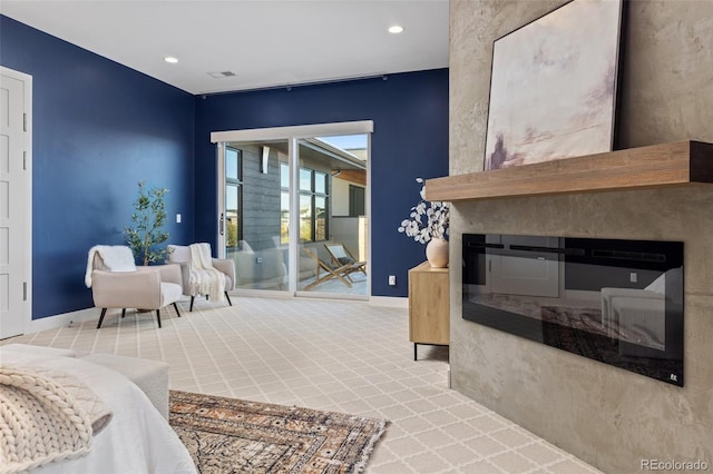 carpeted living room featuring a large fireplace