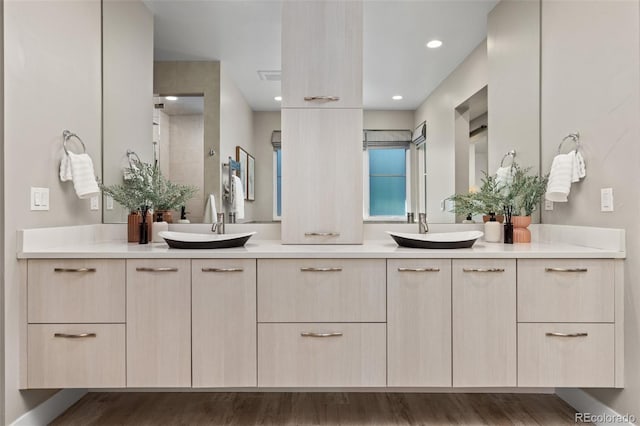 bathroom with hardwood / wood-style flooring, vanity, and walk in shower