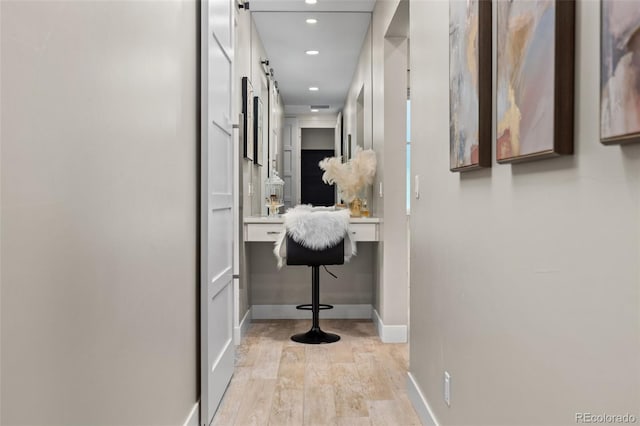 hallway with light hardwood / wood-style floors and a barn door