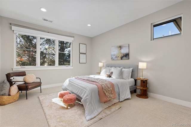 bedroom with multiple windows and light carpet