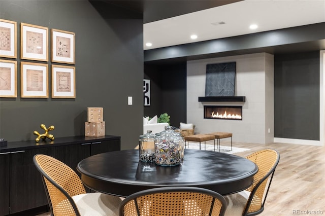 dining area with a fireplace and light wood-type flooring