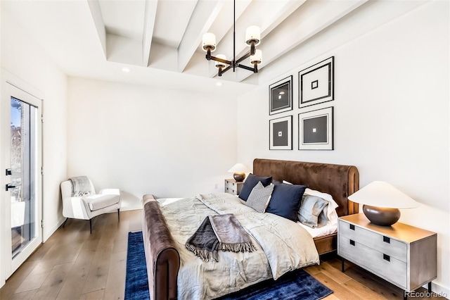 bedroom with wood-type flooring and an inviting chandelier