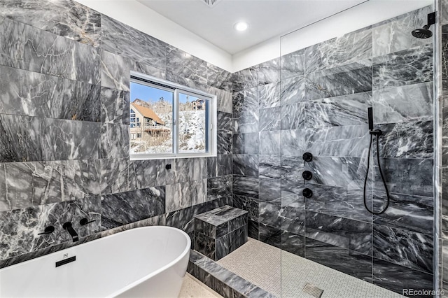 bathroom with tile walls and independent shower and bath