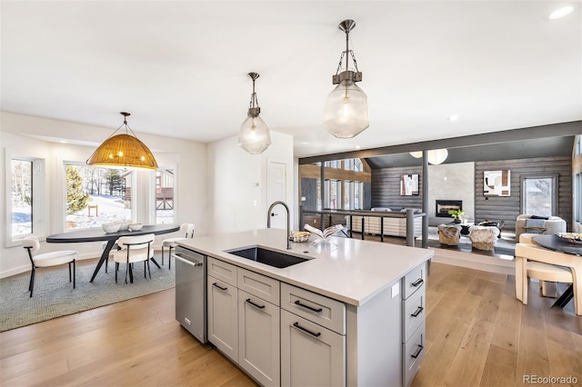 kitchen with sink, pendant lighting, an island with sink, and gray cabinetry