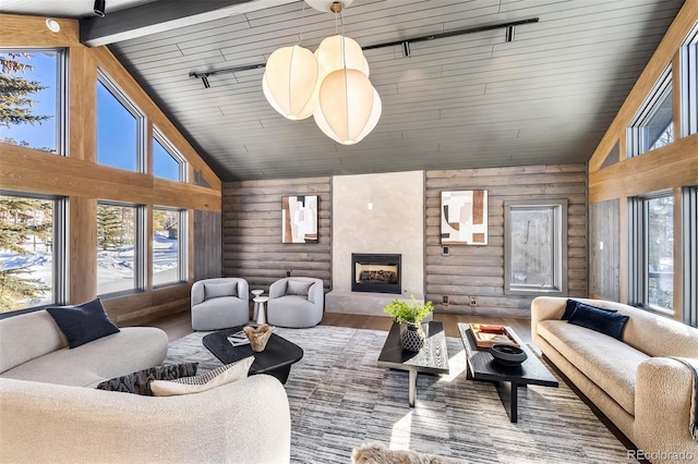 living room featuring wood-type flooring, high vaulted ceiling, a fireplace, and log walls