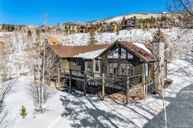 snow covered property featuring a deck with mountain view