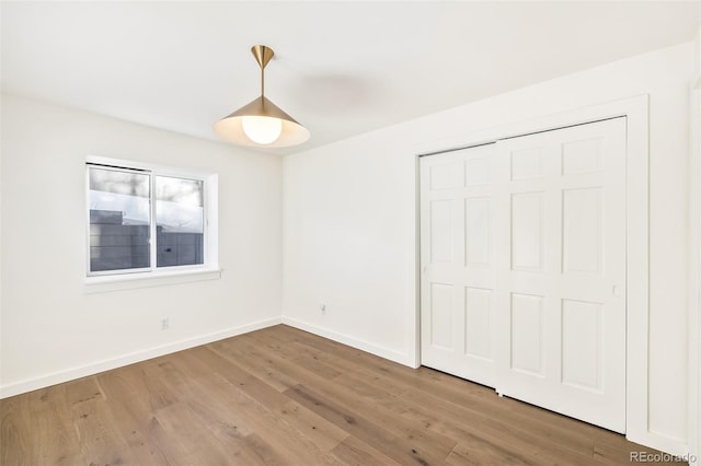 unfurnished bedroom with a closet and hardwood / wood-style flooring