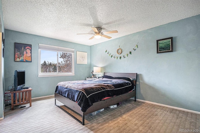 carpeted bedroom with a textured ceiling, baseboards, and a ceiling fan