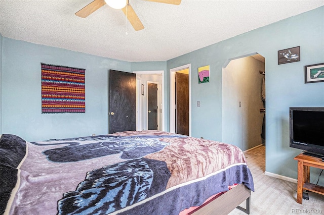 carpeted bedroom with baseboards, ceiling fan, and a textured ceiling
