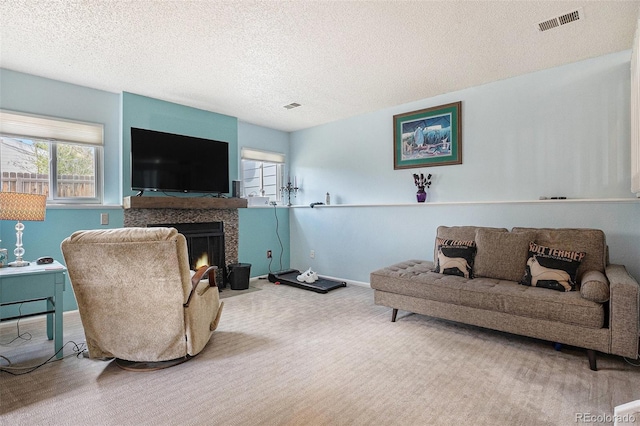 carpeted living area featuring visible vents, a fireplace with flush hearth, baseboards, and a textured ceiling