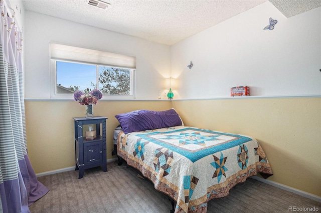 bedroom featuring a textured ceiling, visible vents, baseboards, and carpet
