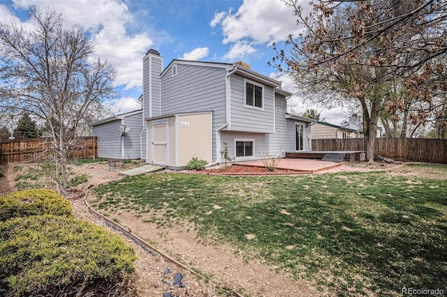 rear view of property featuring a fenced backyard, a patio area, a yard, and a chimney