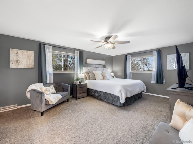 carpeted bedroom featuring baseboards, a ceiling fan, and visible vents