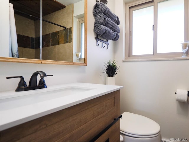 full bathroom featuring vanity, toilet, and tiled shower