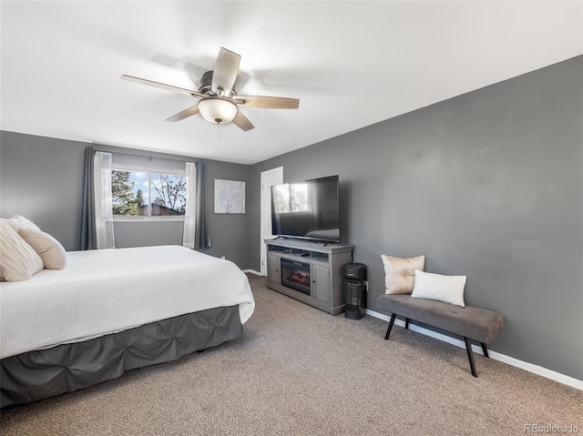 bedroom featuring baseboards, light carpet, ceiling fan, and a fireplace