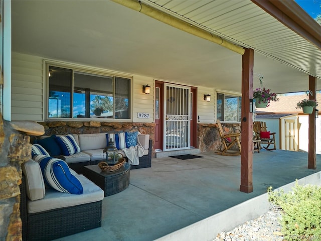 view of patio with a storage unit, an outbuilding, an outdoor hangout area, and a porch