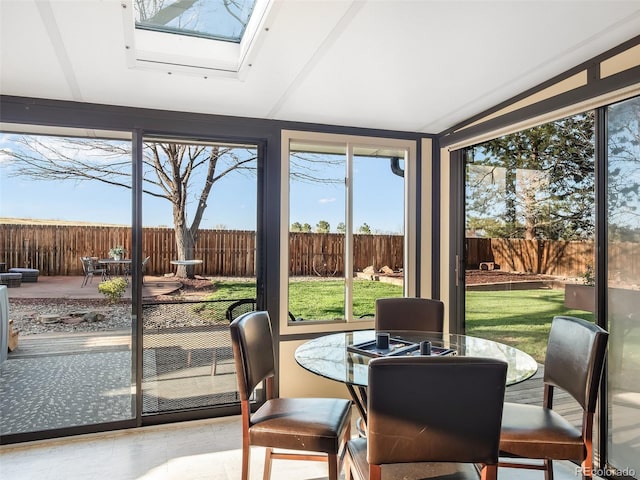 sunroom / solarium featuring vaulted ceiling with skylight