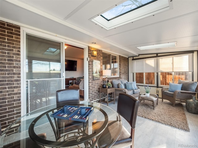 sunroom with outdoor dining area, a skylight, and an outdoor hangout area