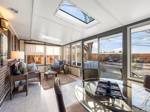 sunroom / solarium featuring a skylight and wood finished floors