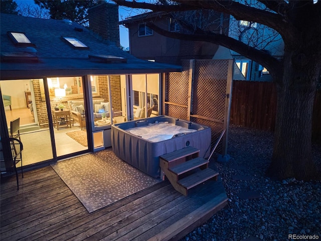 wooden terrace with a hot tub and fence