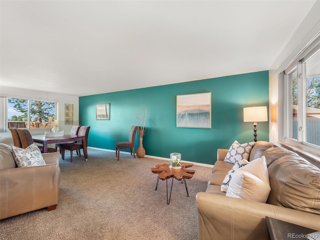carpeted living room featuring baseboards and a wealth of natural light