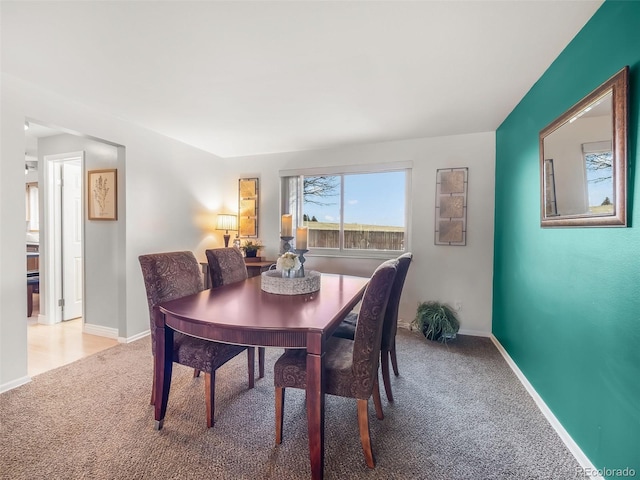 carpeted dining space with baseboards