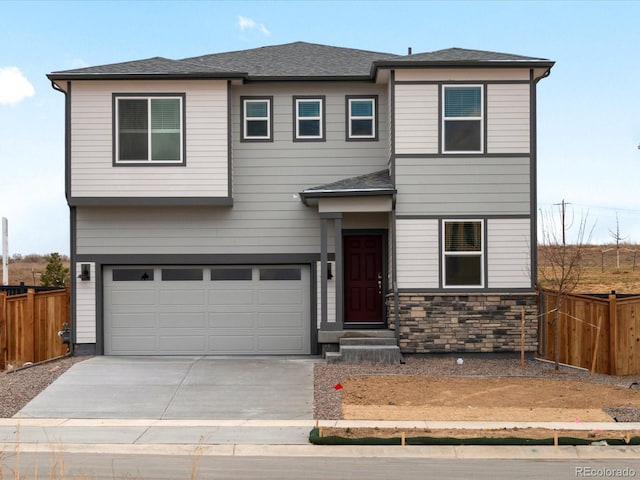 view of front of house with stone siding, an attached garage, fence, and concrete driveway