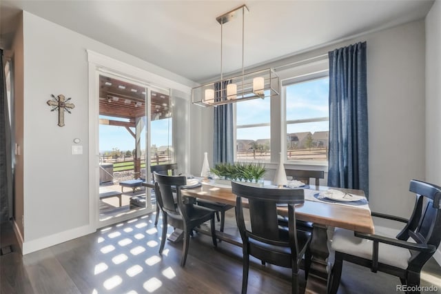 dining area with dark wood-style floors, baseboards, and a chandelier