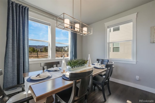 dining room with a notable chandelier, dark wood-style flooring, visible vents, and baseboards