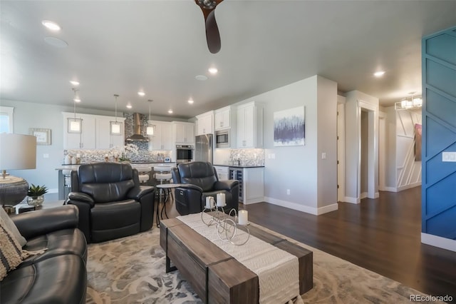 living area featuring baseboards, dark wood finished floors, and recessed lighting