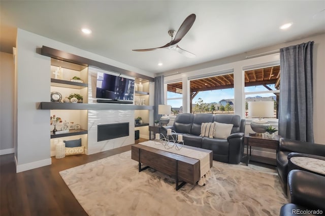 living area with a fireplace, a ceiling fan, wood finished floors, and recessed lighting