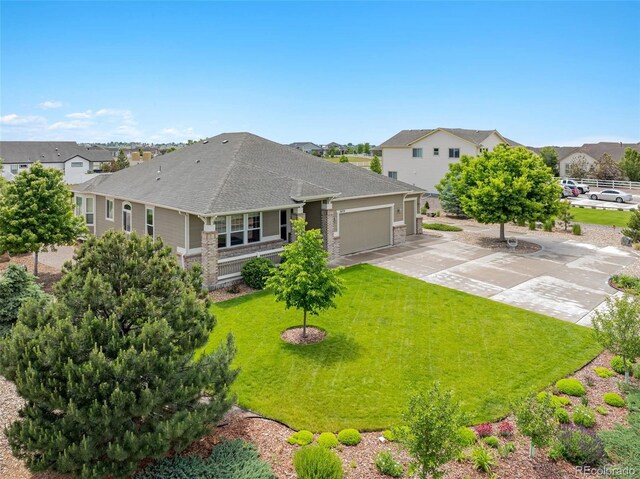 16231 Rayburn St, Hudson, CO 80642 - rear view of house with a garage, driveway, a lawn, roof with shingles, and a residential view