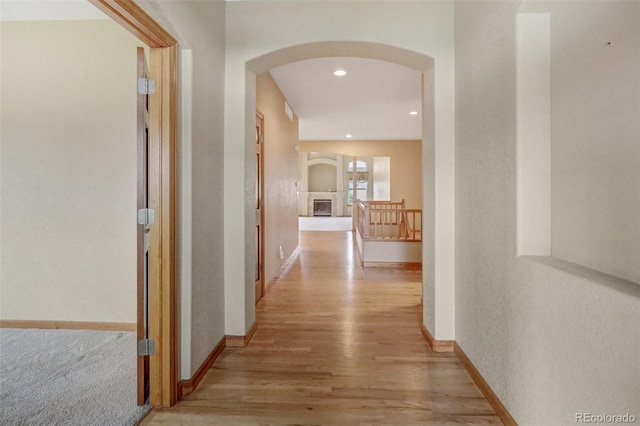 16231 Rayburn St, Hudson, CO 80642 - hall featuring arched walkways, light wood finished floors, baseboards, and recessed lighting
