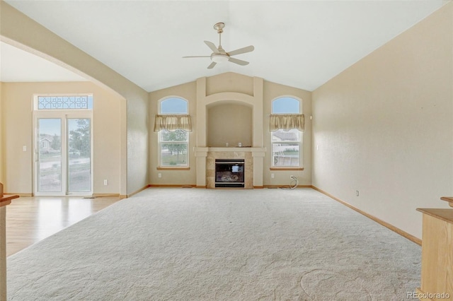 16231 Rayburn St, Hudson, CO 80642 - unfurnished living room with ceiling fan, baseboards, a tiled fireplace, high vaulted ceiling, and carpet floors