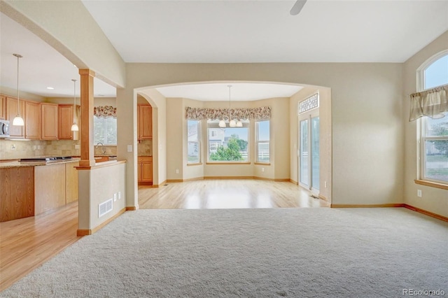 16231 Rayburn St, Hudson, CO 80642 - kitchen with open floor plan, baseboards, tasteful backsplash, light wood-style flooring, and decorative light fixtures