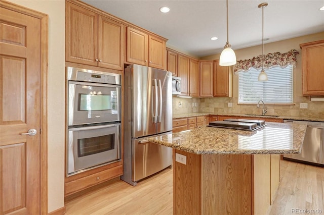 16231 Rayburn St, Hudson, CO 80642 - kitchen with appliances with stainless steel finishes, a sink, light wood finished floors, tasteful backsplash, and recessed lighting