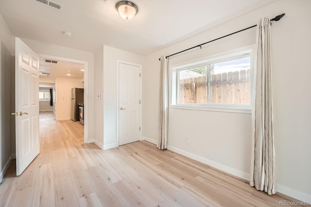 1533 E Harlan, Lakewood, CO 80214 - unfurnished bedroom featuring freestanding refrigerator, light wood-type flooring, and baseboards