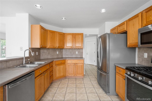 6193 Terry Ct, Arvada, CO 80403 - kitchen with stainless steel appliances, a sink, decorative backsplash, light tile patterned flooring, and recessed lighting