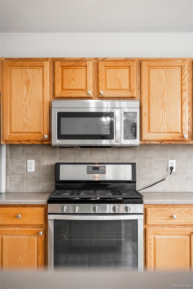 6193 Terry Ct, Arvada, CO 80403 - kitchen with appliances with stainless steel finishes, light countertops, and tasteful backsplash